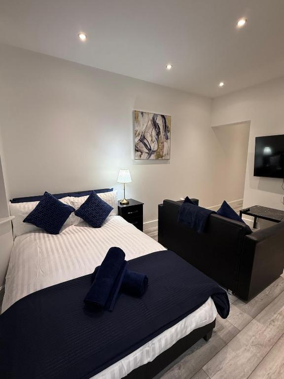 a bedroom with a large bed with blue pillows at Stylish Studio Apartment in Leicester