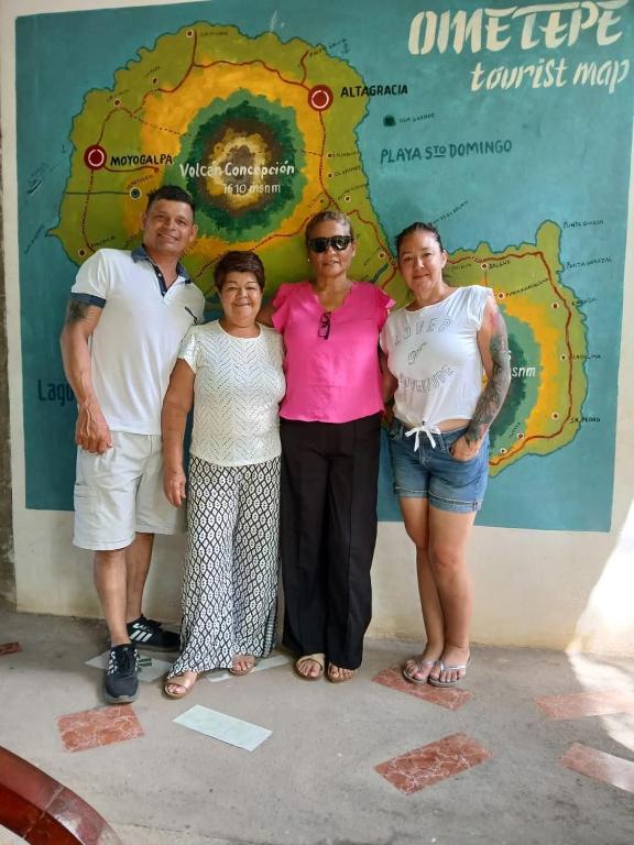 un groupe de personnes debout devant un mur dans l'établissement Rancho Caballo Blanco, à Moyogalpa