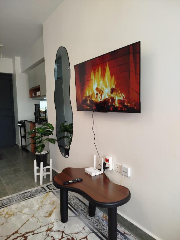 a living room with a fireplace on the wall at Kiambu cozy studio in Kiambu