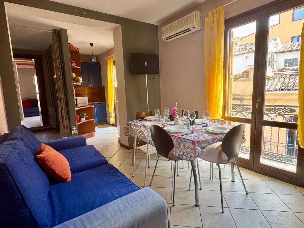 een woonkamer met een blauwe bank en een tafel met stoelen bij Akragas home 2 in Center with City View in Agrigento