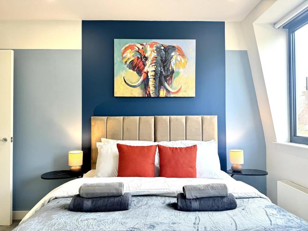 ein Schlafzimmer mit einem Elefantengemälde an der Wand in der Unterkunft Contemporary Designer 2 Bed Apartment, Free Parking, Gym, Yoga & Cinema Room in Bedford