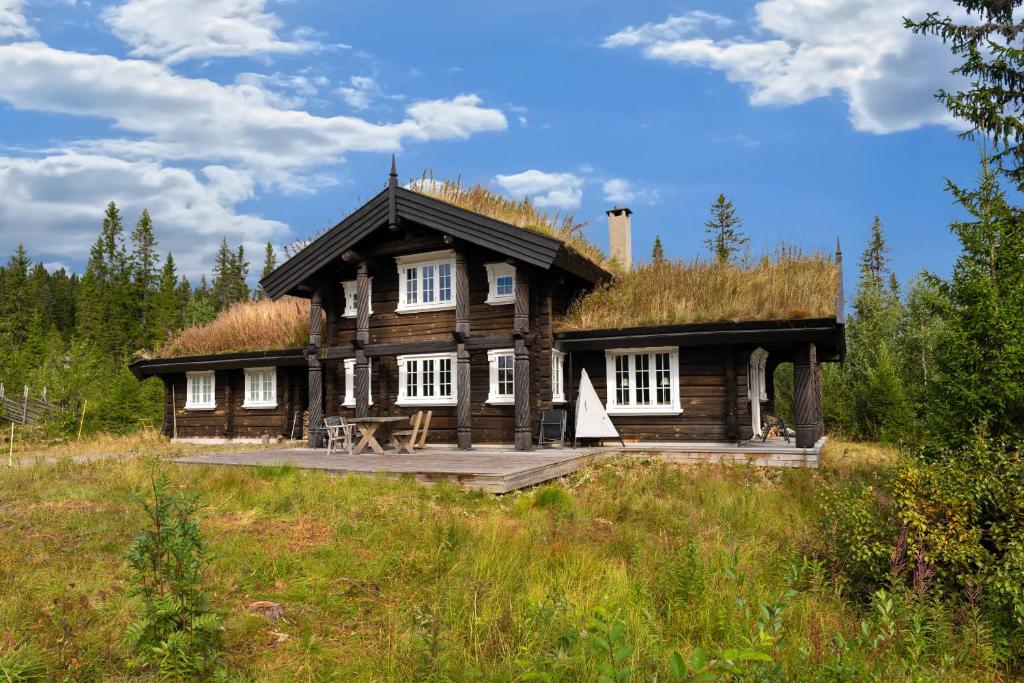 een blokhut met een grasdak op een veld bij Trysilfjell 811 by Vacation Trysil in Mælem