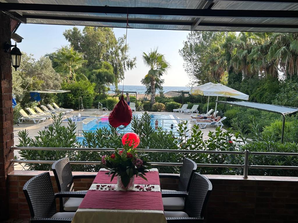 a table with a vase of flowers on top of a patio at Hotel Grün in Kızılot
