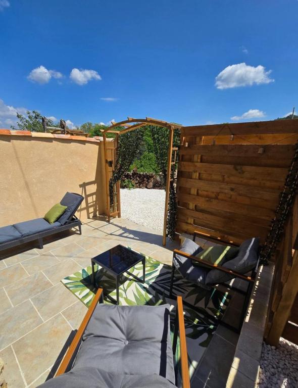 a patio with chairs and a wooden fence at Mini Loft à la campagne La BA-LINE in Entrecasteaux
