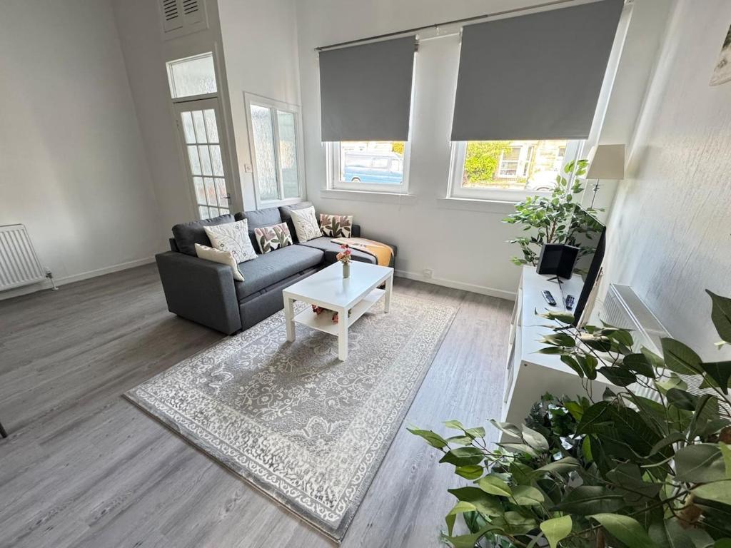 a living room with a couch and a table at Spacious 2BR Home by Portobello Beach in Edinburgh
