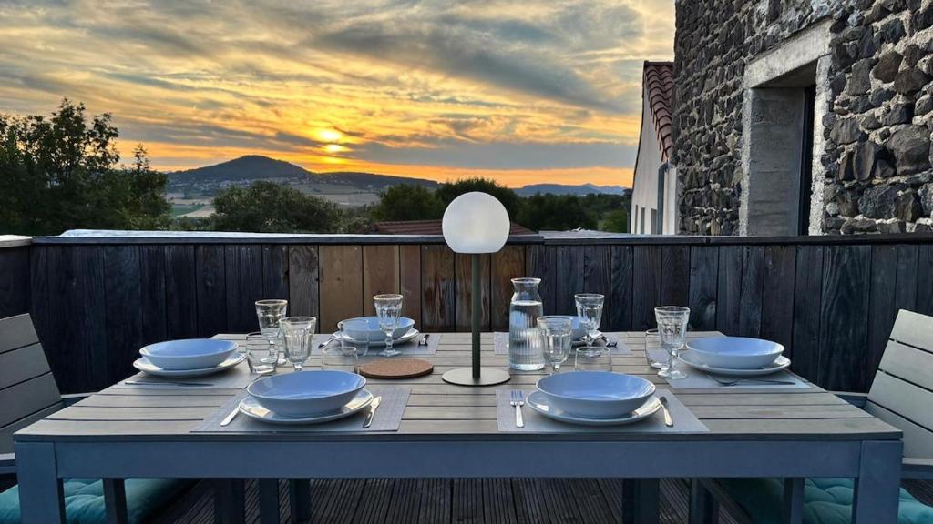 een tafel met borden en glazen op een terras met de zonsondergang bij Casalleia in Bergonne