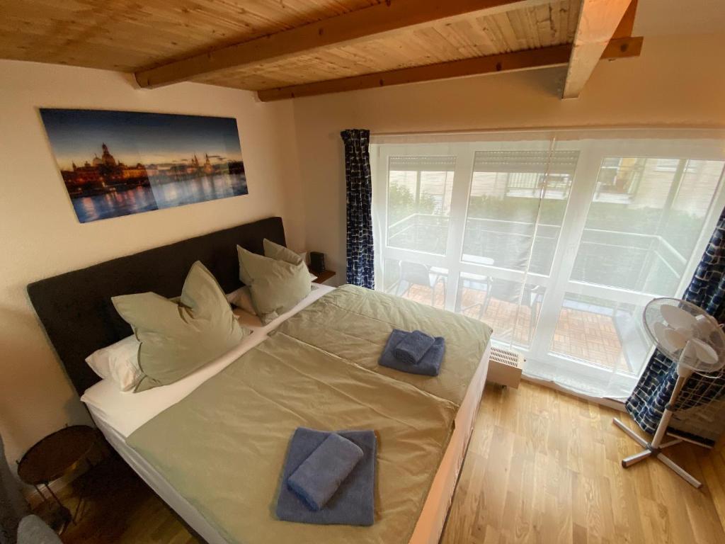Un pat sau paturi într-o cameră la Saxonia HomeDeLuxe Appartement Dresden Neue Hochwertige voll ausgestattete Ferienwohnung mit Küche XXL Boxspringerbett 2 Einzelbetten Highspeed InternetFlatrate und Balkon Ideal für Familien Paare Kulturinteressierte und Geschäftsreisende mit MWStRechnung