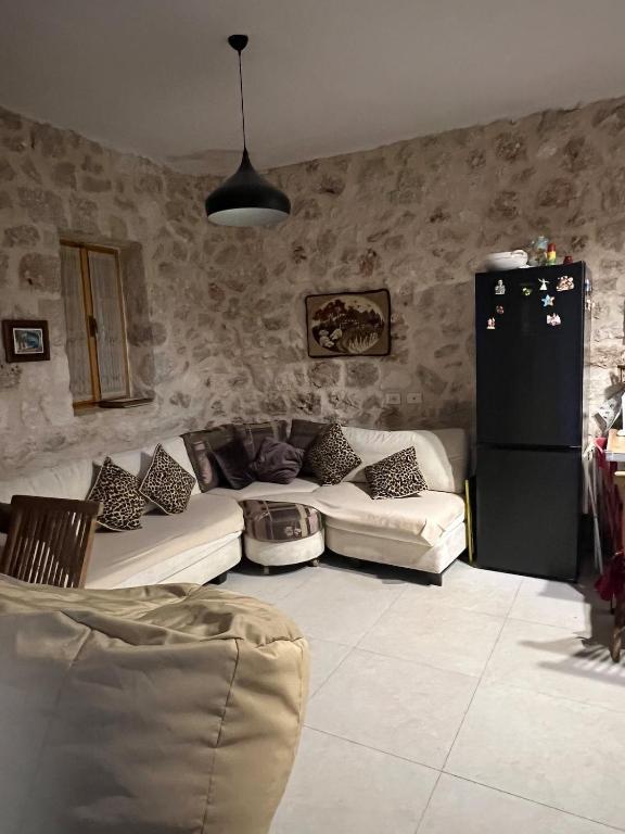 a living room with two couches and a refrigerator at Nils Home in Dhërmi