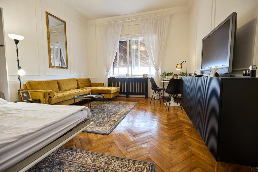 a bedroom with a bed and a living room with a couch at Piac 16 apartman a belváros szívében in Debrecen