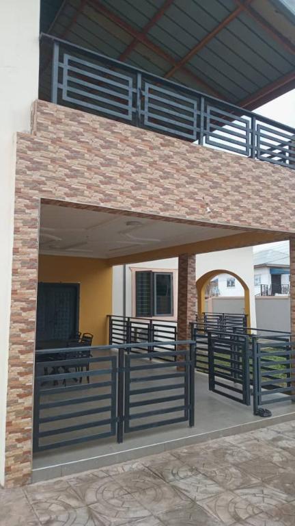 a covered deck with benches on a building at CARL's VILLA 2 Bedroom APARTMENT in Accra