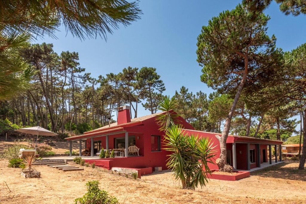 a red house in the middle of trees at Sintra - Praia Grande Village in Colares