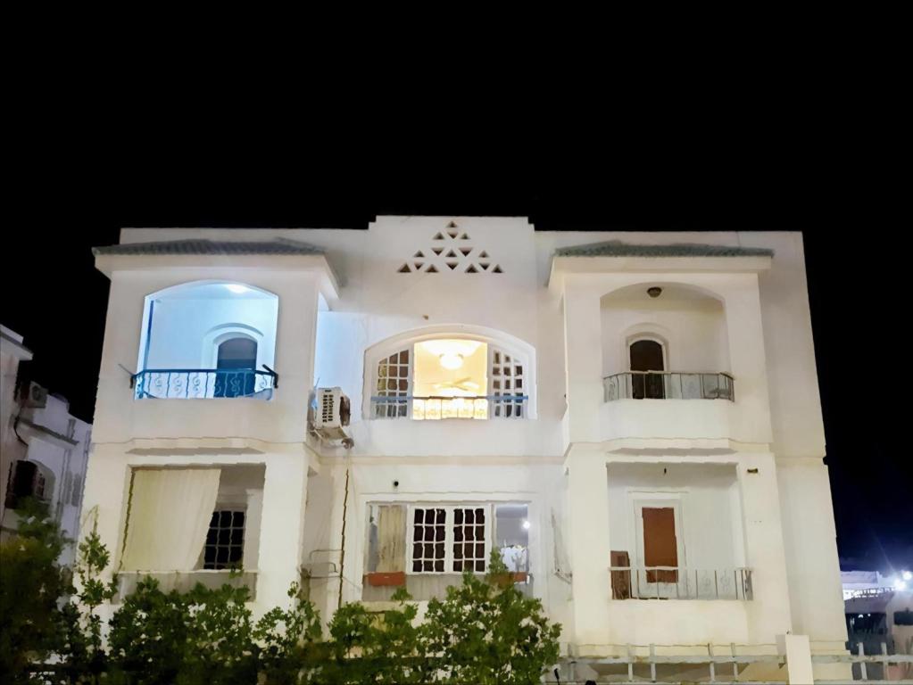 a white building with two balconies and a blue window at hassan apartments in Sharm El Sheikh