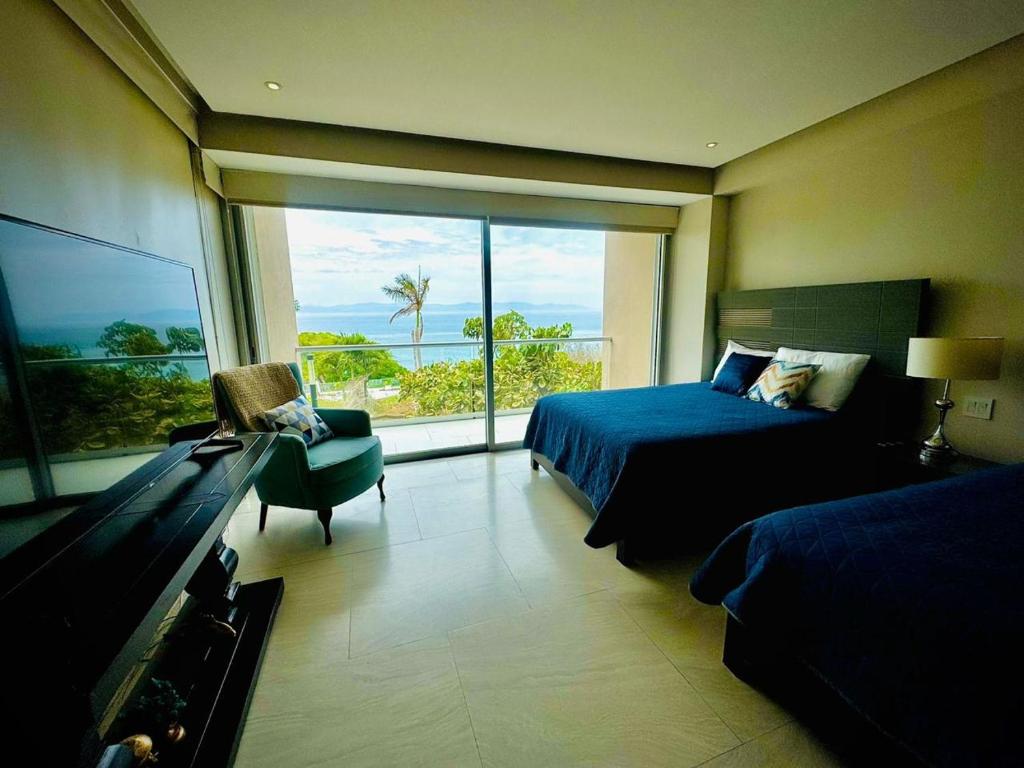 ein Schlafzimmer mit einem Bett und einem großen Fenster in der Unterkunft Gu-F1 in Higuera Blanca