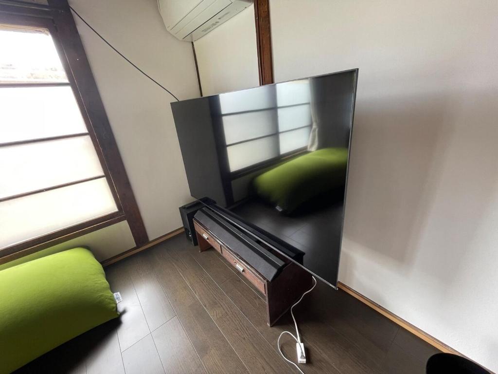 福島市にある昭和の家anzu 二階建ての一棟貸切のリビングルーム(テレビ、緑のソファ付)