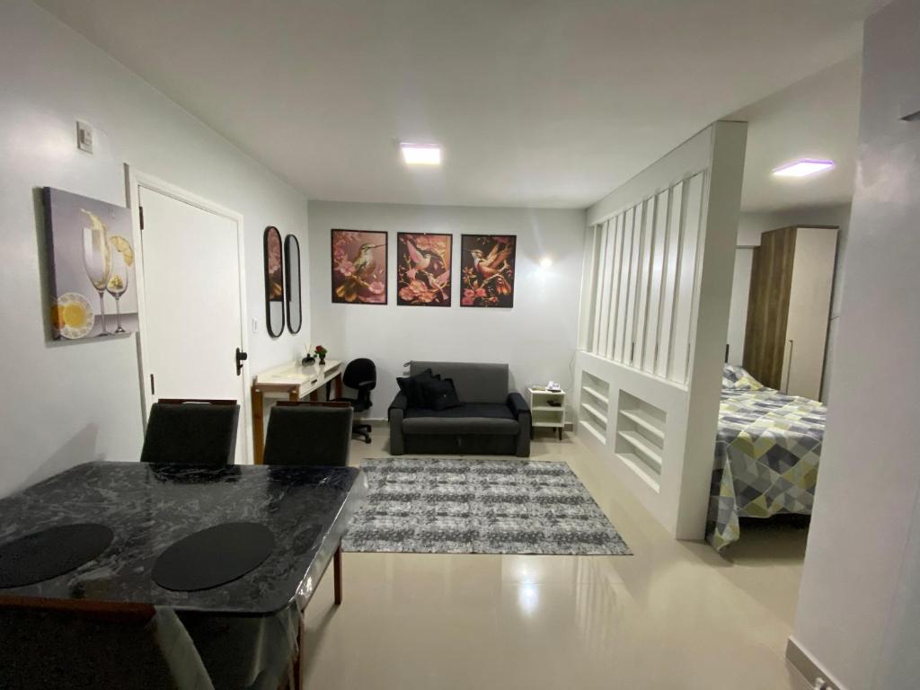 una sala de estar con un sofá y una cama en Flat da Belly 904-A, en São Vicente