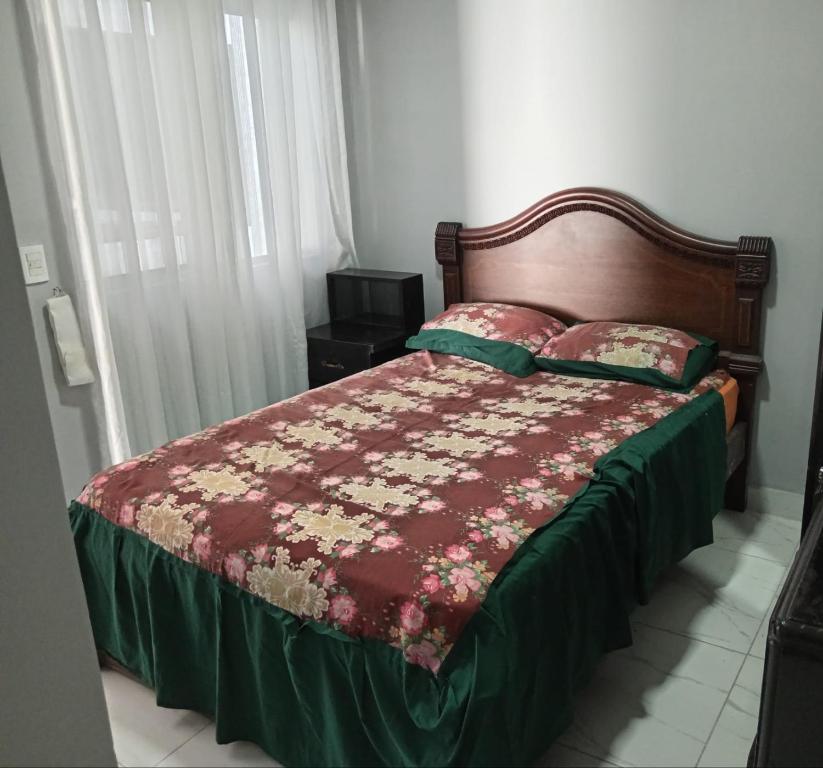 Schlafzimmer mit einem Bett mit einer roten Bettdecke in der Unterkunft Casa Hnas Landivar Figueroa in Hamacas