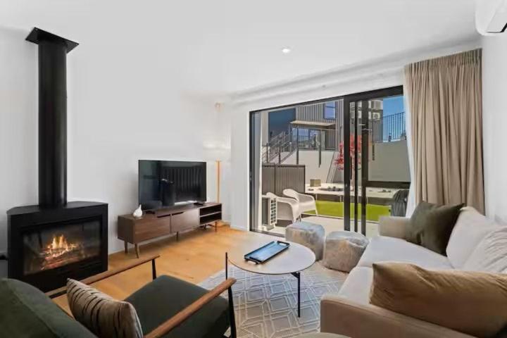 a living room with a couch and a fireplace at Wanaka Getaway - Bright 2-Bed Apartment in Wanaka