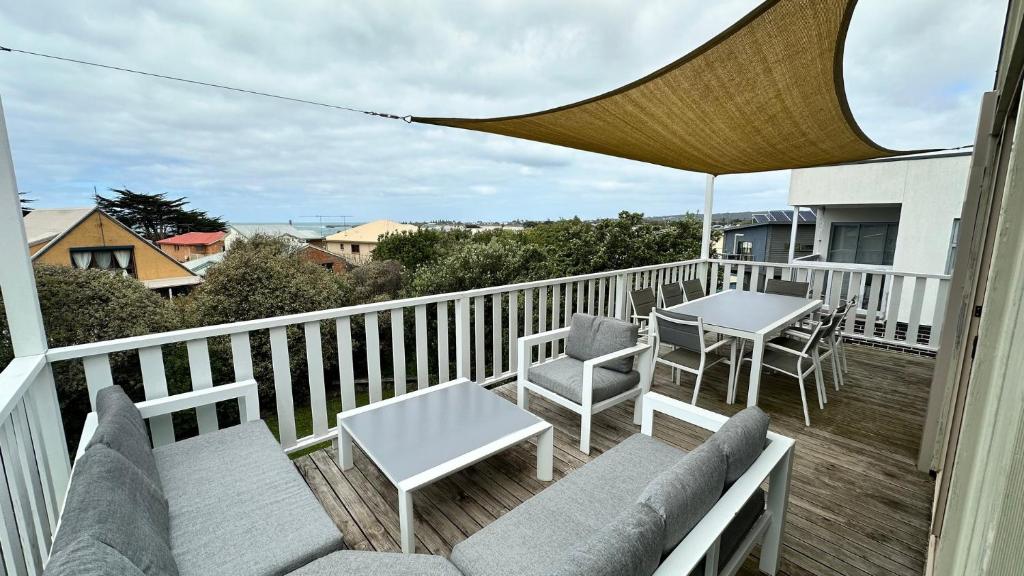a balcony with chairs and tables and an umbrella at Dolphin in Apollo Bay