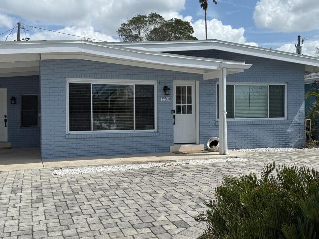 una casa blu con un cane seduto di fronte di Indian Rocks Beach Cottage a Clearwater Beach