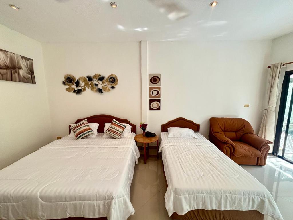 a bedroom with two beds and a couch at Paradise House in Thai Muang