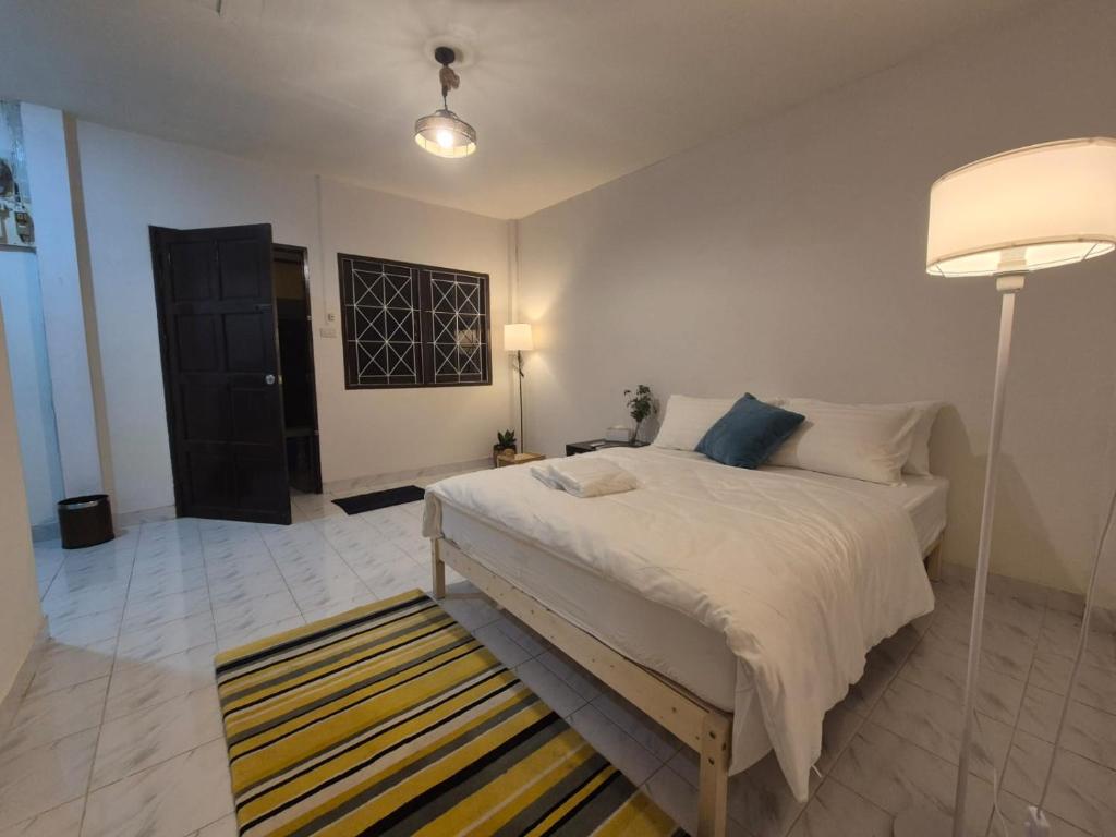 a bedroom with a bed with a lamp and a rug at Friends Retreat Phuket in Ban Bo Han