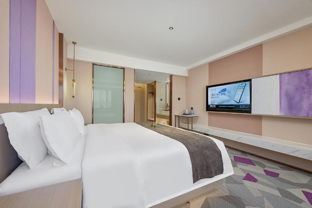 a bedroom with a large bed and a flat screen tv at 麗枫酒店广州番禺汉溪长隆大石地铁站店 in Guangzhou