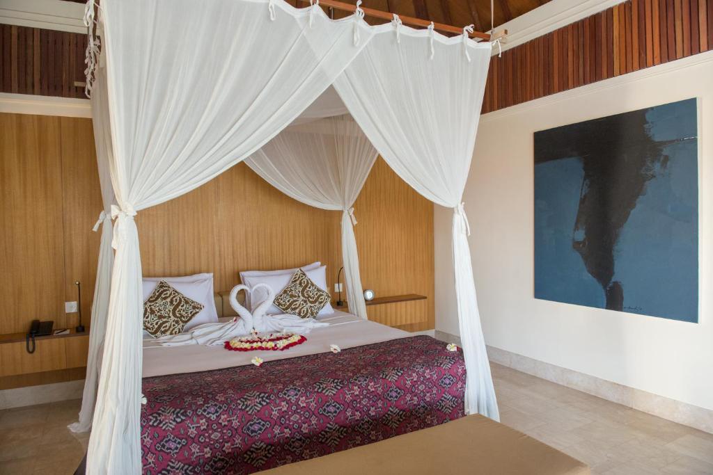 Postel nebo postele na pokoji v ubytování Komaneka at Rasa Sayang Ubud