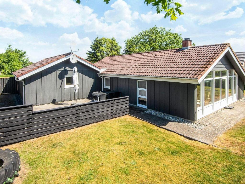 a house with a fence and a yard at Tranquil Oasis by Fjord - By Traum Ferienwohnungen in Hemmet