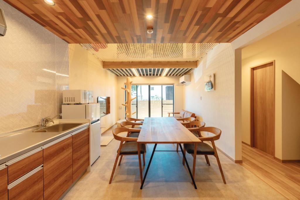 a kitchen and dining room with a table and chairs at YOUR ROOM treehouse KUMAMOTO in Kumamoto