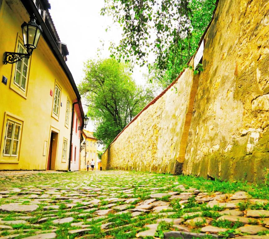 a cobblestone street next to a stone wall at Garden Residence Prague Castle in Prague