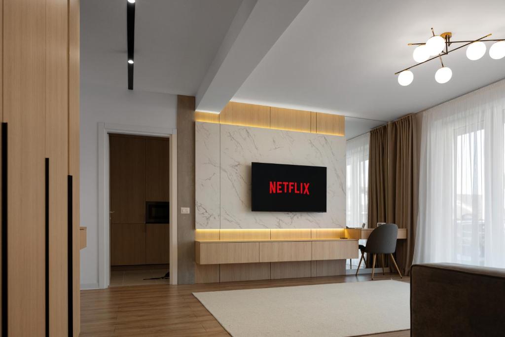 a living room with a television on a wall at Nido Uno Brașov in Braşov