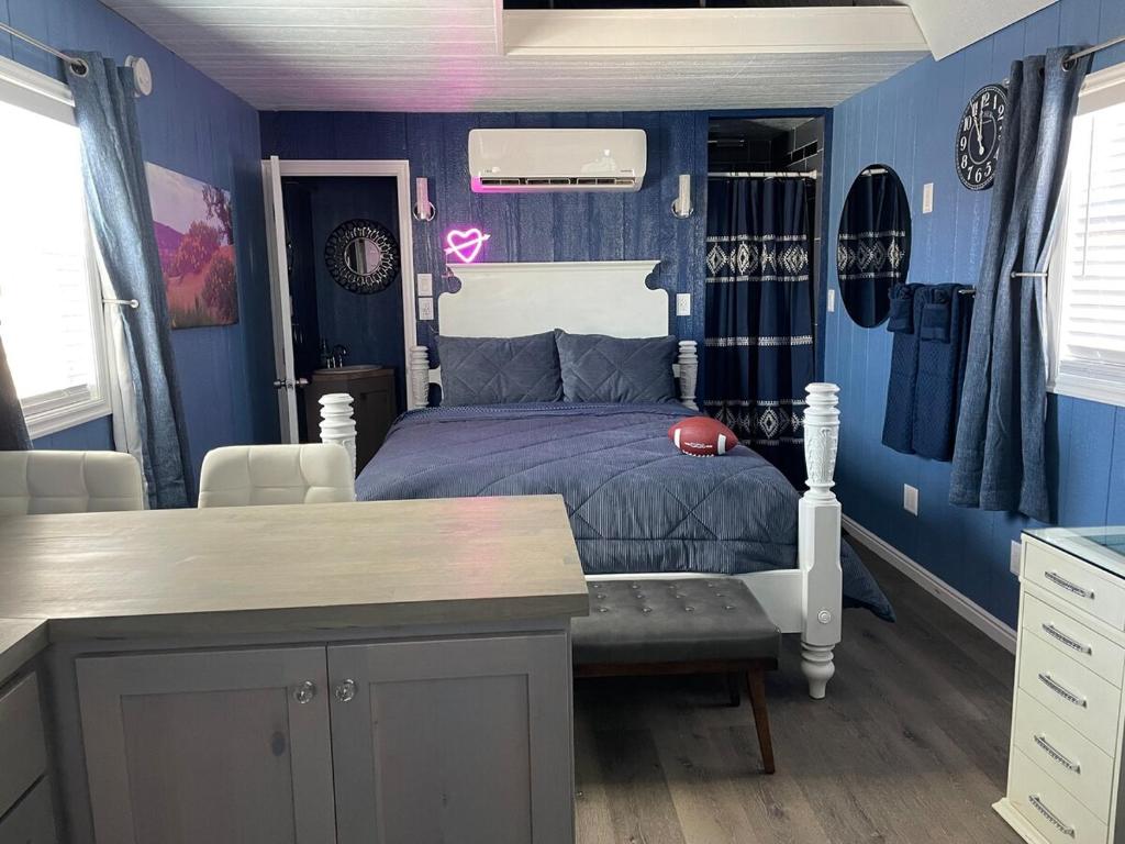 a bedroom with blue walls and a bed and a table at Denim and Diamonds in Cane Beds
