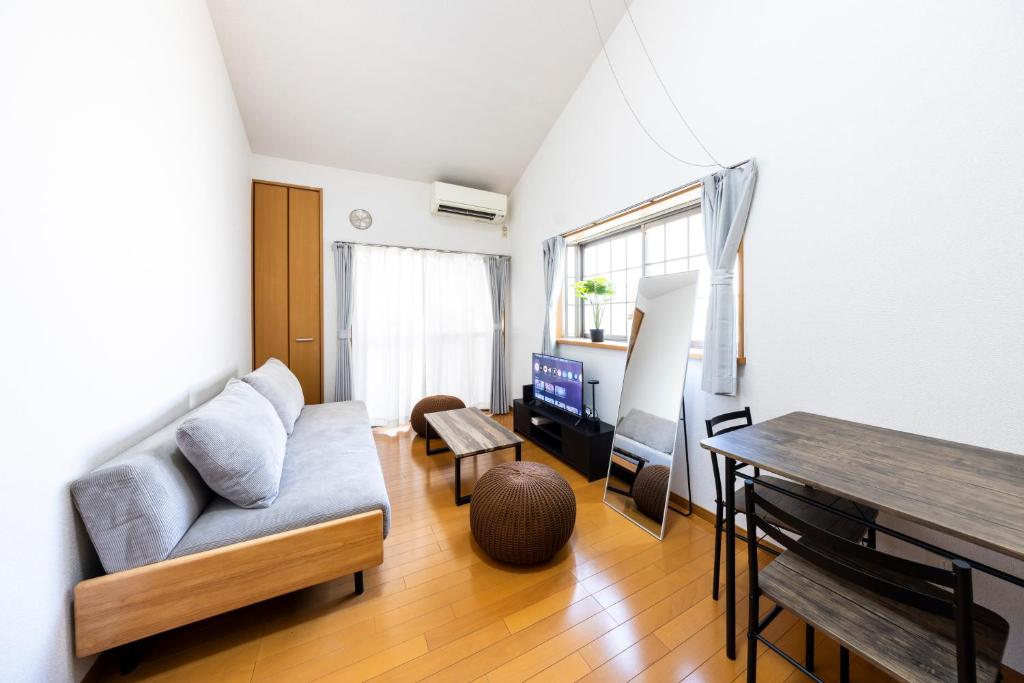 ein Wohnzimmer mit Sofa und Tisch in der Unterkunft IL Regalo Tenjin2 Street Stay in Fukuoka