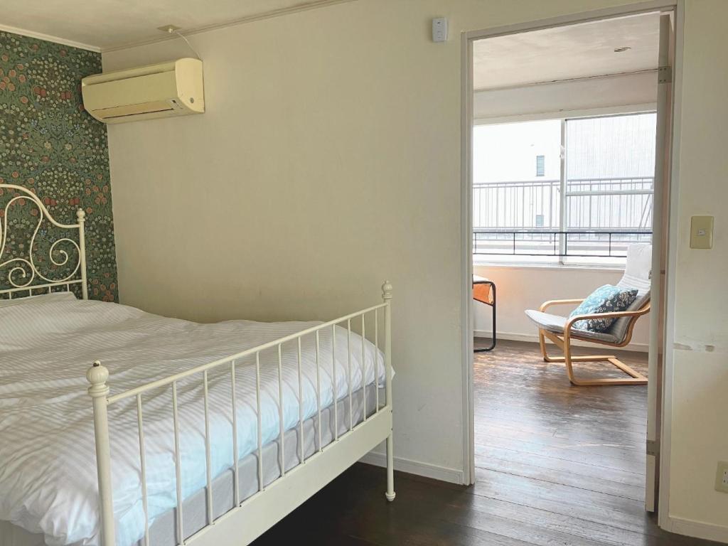a bedroom with a bed and a chair and a window at Ivy Cottage 3F - Vacation STAY 42187v in Kumamoto