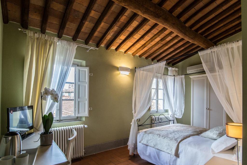ルッカにあるB&B Residenza Di Via Fontanaのベッドルーム1室(ベッド1台、窓2つ付)