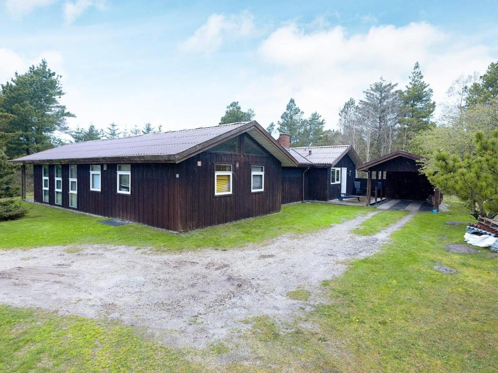 una casa con un gran patio con una casa en 12 person holiday home in Pandrup-By Traum, en Rødhus