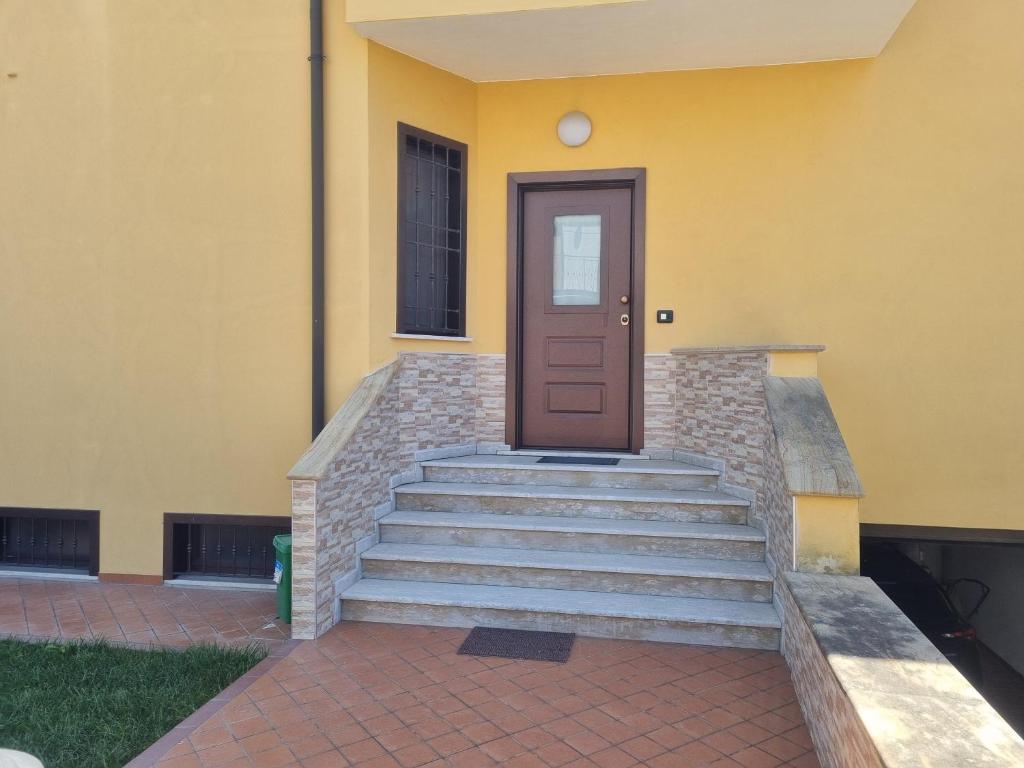 a yellow building with stairs and a door at La perla marina in Cellole