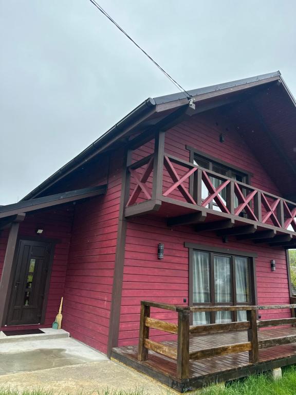 a red building with a balcony on the side of it at Фазенда in Vorokhta