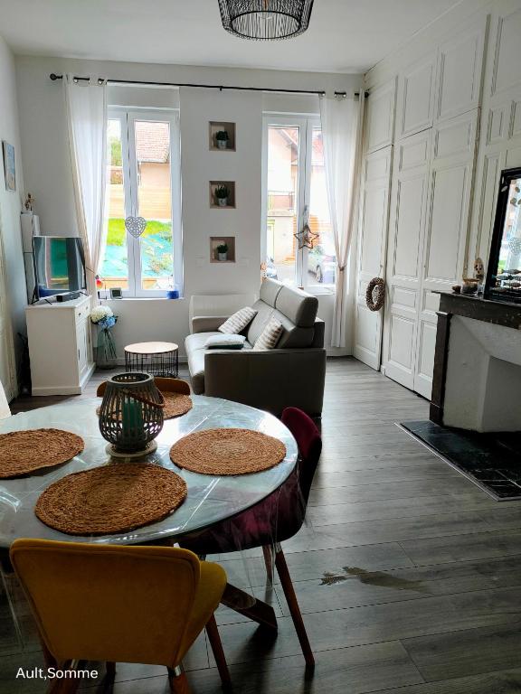 a living room with a table and a couch at La parenthèse in Ault