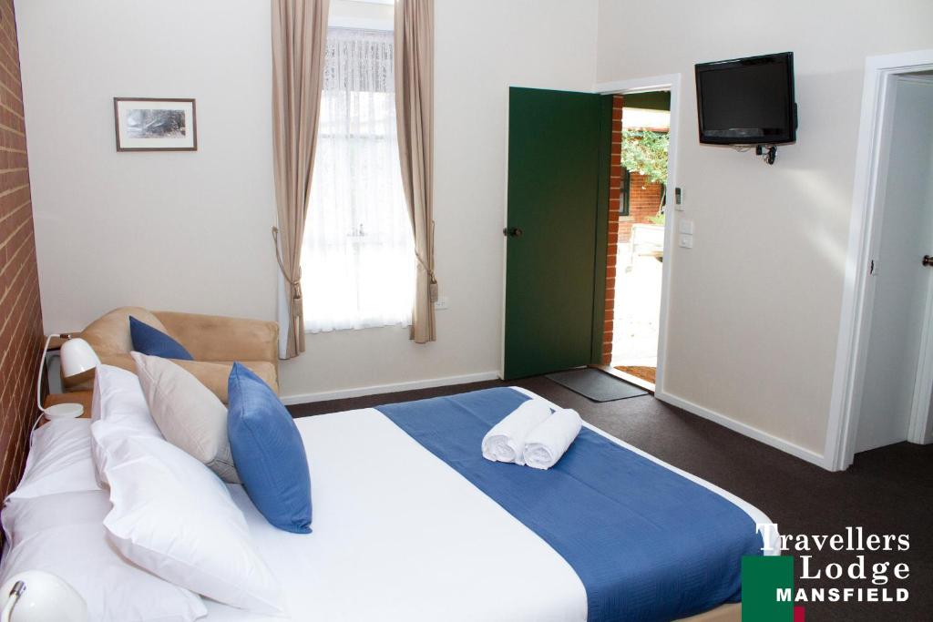 sypialnia z dużym łóżkiem z niebiesko-białymi poduszkami w obiekcie Mansfield Travellers Lodge w mieście Mansfield