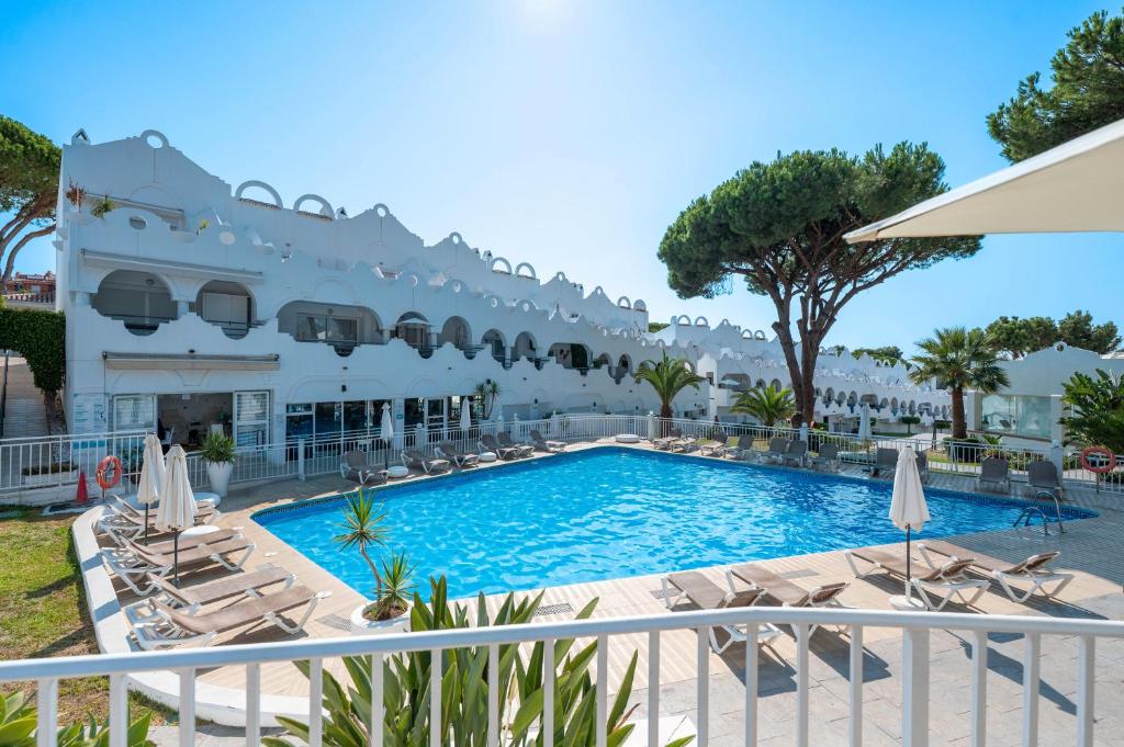 a pool at a hotel with chairs and umbrellas at Casa Latifa in Marbella