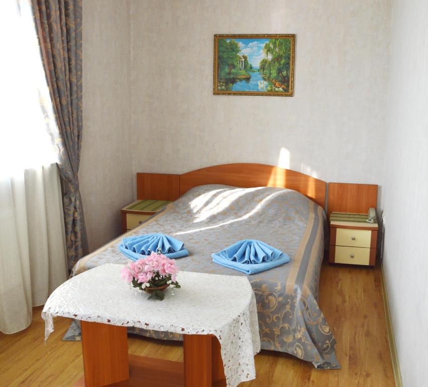 アナパにある''ANI'' на Севернойのベッドルーム1室(ベッド1台、花のテーブル付)