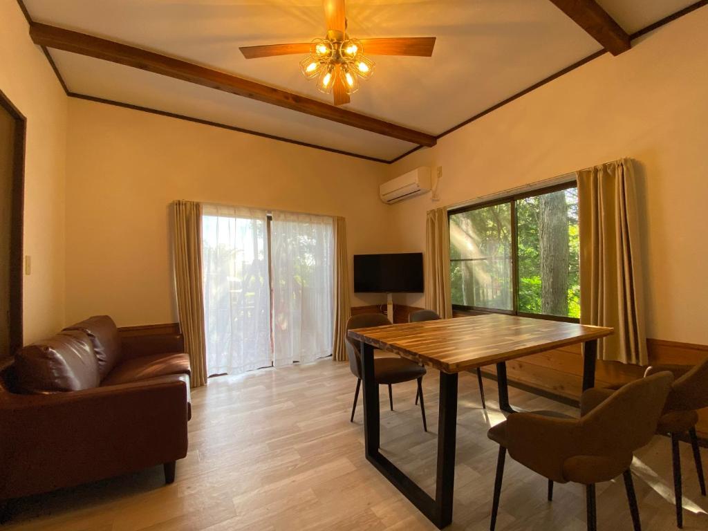 a living room with a wooden table and a couch at 天然プラネタリウムcottage星空E棟 in Anazawa