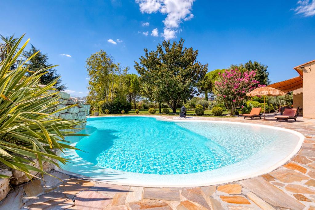 una piscina con acqua blu in un cortile di L'évaroma a Campagne