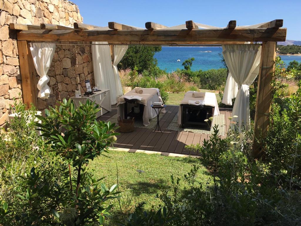 a pergola with a table and chairs in a yard at Cala Cuncheddi - VRetreats in Murta Maria