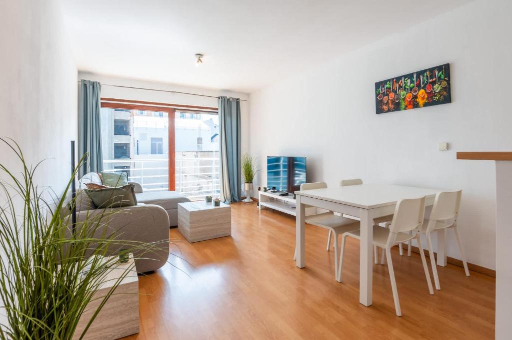 a living room with a white table and chairs at Cosy condo in the city centre in Ostend