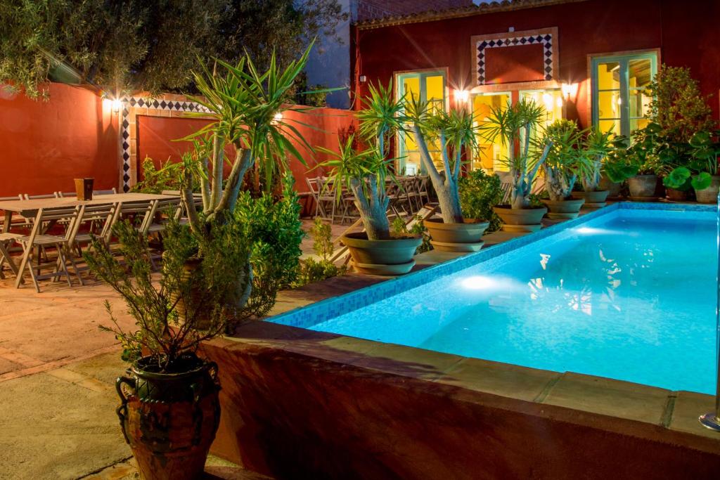 a swimming pool with potted plants next to a restaurant at Villa Lupita in Alquerías del Niño Perdido