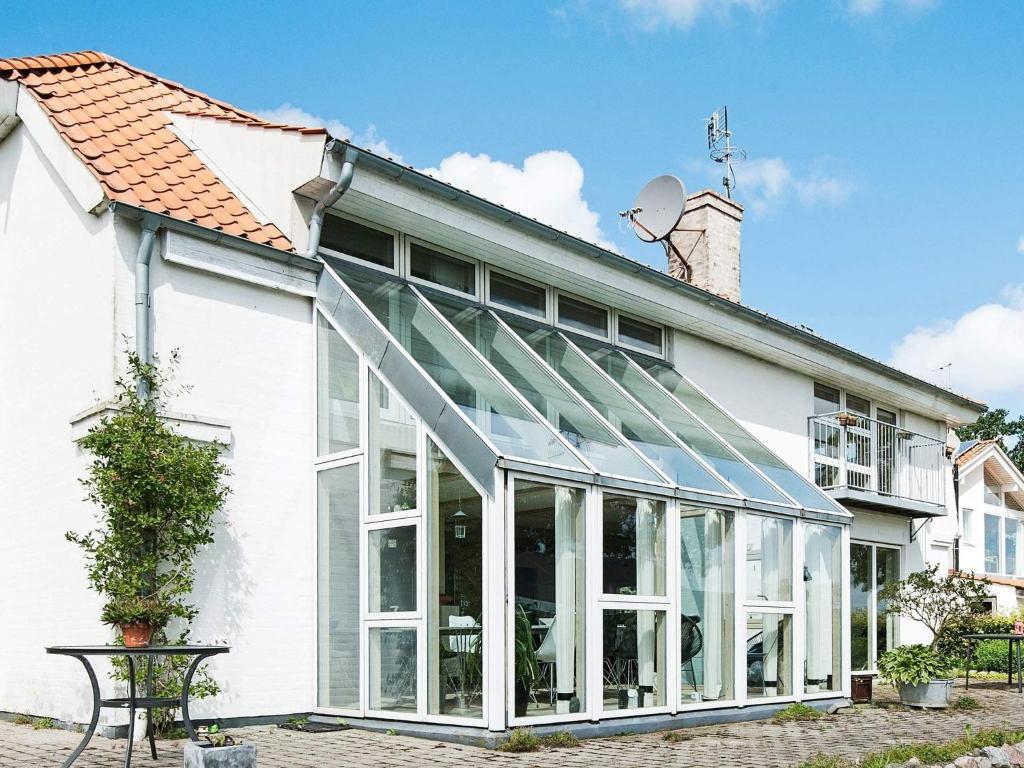 a white house with a conservatory on the side of it at Luxury Seaside Retreat - By Traum Ferienwohnungen in Årøsund