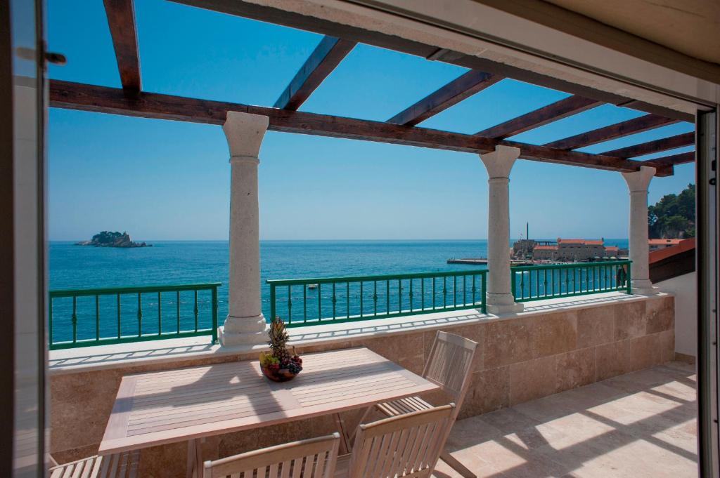 einen Balkon mit einem Tisch und Meerblick in der Unterkunft Piazza Apartments 1 in Petrovac na Moru