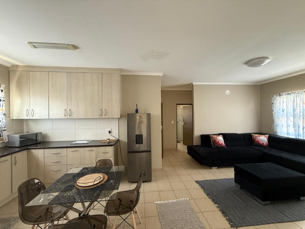 a kitchen and a living room with a table and a couch at Ocean View Cottage in Swakopmund